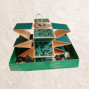 vue de côté de la carte accordéon artisanale motif florale dans les tons de vert et de bleu.