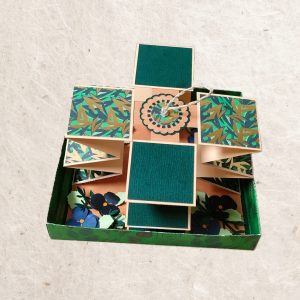 vue de dessus de la carte accordéon à la décoration florale dans les ton de vert et bleu.